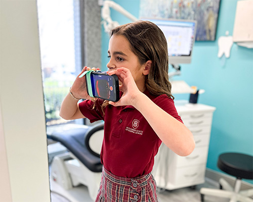 young girl using the grin scan box to get a scan of her smile for dr patel
