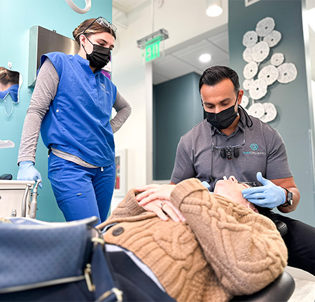 adult patient discussing treatment in dental chair with dr patel
