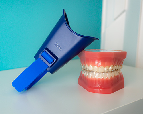 grin smile scan box leaning against a set of model teeth